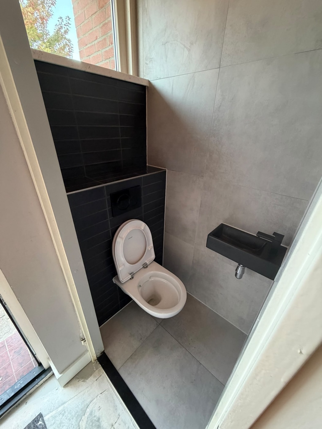 Overzicht van de toilet renovatie in Alphen aan den Rijn met zwevend toilet en zwarte design wastafel