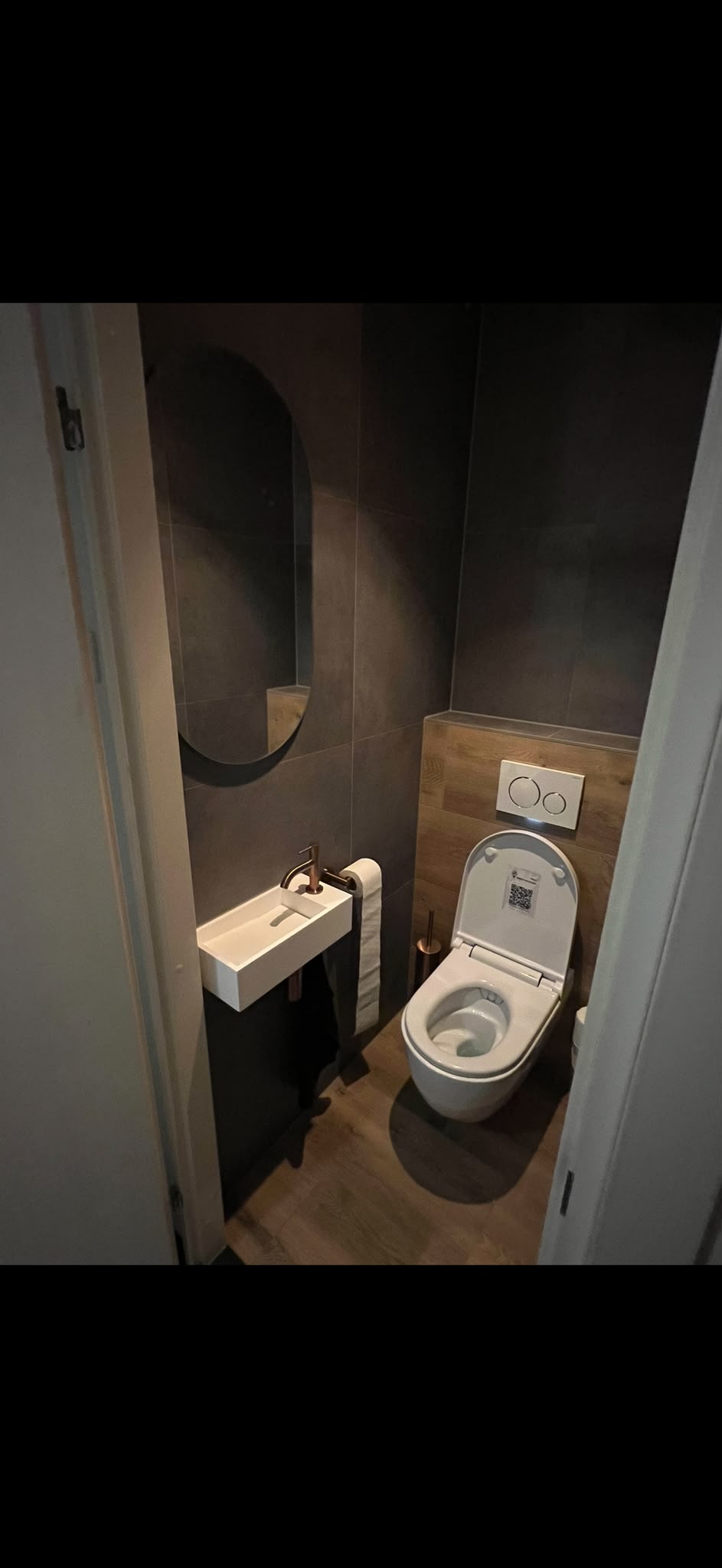 Smalle gasten-wc met grijze tegels, eiken achterwand en fontein
