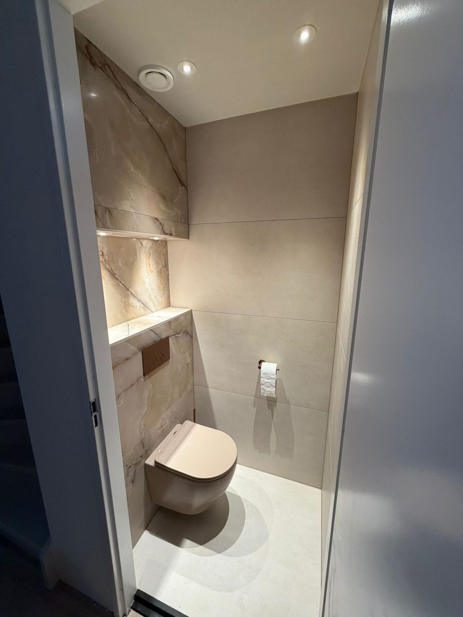 Compact toilet met warme marmerlook, zwevend toilet en verlichte nis
